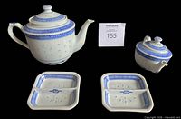 Group shot of both teapots with lids and two square side dishes