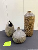 Three vases displayed together showing relative sizes and finishes