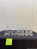 Full grouping of assorted clear glasses arranged on table