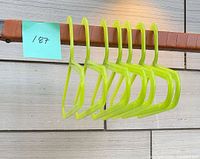 seven neon yellow plastic hangers grouped on rod