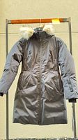 Front view of black Nobis Scout coat on hanger showing full length, zip closure, pockets, fur-trim hood