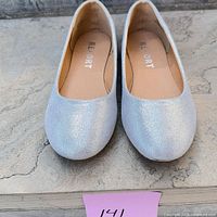 Top view of both silver glitter ballet flats