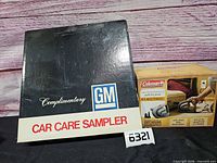 GM Car Care Sampler box beside Coleman air pump box