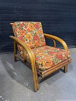 Front angled view of chair showing rattan frame and floral cushions