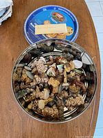 Open biscuit tin filled with assorted Wade Red Rose Tea figurines