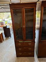 Front view of mahogany display cabinet with two glass doors and three drawers