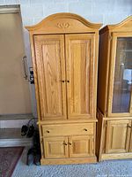 Front view of oak entertainment armoire closed