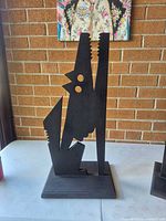Front view of black wood coyote silhouette on base
