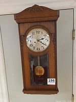 Full front view of oak wall clock hanging on wall