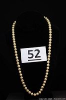 Full view of pearl necklace on bust