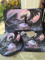 Entire 3-piece dragon bathroom set laid out; rectangular mat, contour rug, lid cover visible
