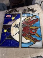 Both stained glass panels side by side showing overall design and chains