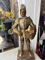 Front view of metal knight showing spear, shield and armor details