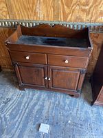 Front view of wooden cabinet showing drawers and doors