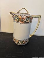 Side view of Nippon porcelain cocoa pot showing floral Art Nouveau bands and gilded handle, rim and lid