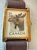 Close-up of watch dial showing 1953 3¢ Moose stamp design and case condition