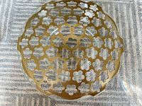 Top view of clear glass bowl with gold perforated metal insert