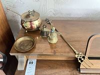 All six brass pieces grouped on shelf