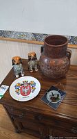 Group view of urn, two dog figurines, Bavaria plate and stained-glass panel