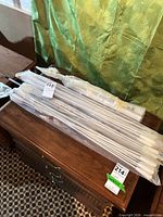 Group of packaged metal curtain rods on furniture