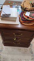 Front and top view showing three drawers and brass pulls