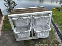 Front view of trolley showing four baskets in frame beside water backdrop