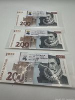Three Slovenian 200 Tolarjev banknotes in sleeves with labels visible