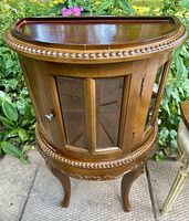 Full view of curved glass cabinet front and legs