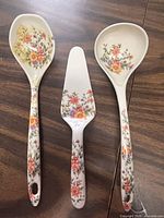 Front view of three floral melamine utensils