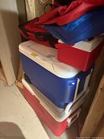 Stack of three hard coolers and red soft cooler bag
