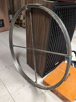 Full view of coiled metal strapping ring leaning against speaker