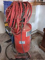 Full view of red Porter-Cable vertical air compressor with coiled hose