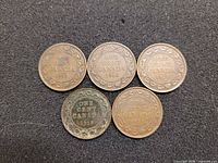 Five coins reverse side showing dates 1915-1919