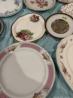 Assorted plates and dishes showing floral patterns, gold accents, variety of sizes