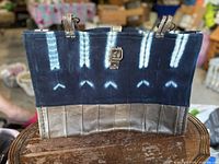 Front view showing indigo textile, leather base, clasp