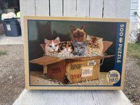 Front of Cobble Hill puzzle box showing cat illustration and piece count