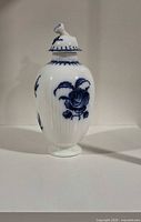 Full front view of vase with lid showing floral design and ribbed body
