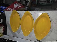 Three yellow oval plates top view