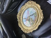 Front view of oval frame and needlepoint artwork