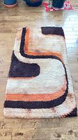 Full view of rectangular shag rug showing geometric pattern and colorway