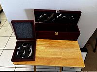 Both open boxes showing interiors and wine tools