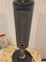 Full view of Lasko ceramic tower heater on base with cord visible