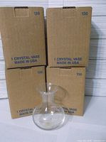 Four cardboard boxes marked 130 with one clear crystal vase displayed