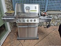 Front view of Napoleon 450 grill with side shelves and tool set