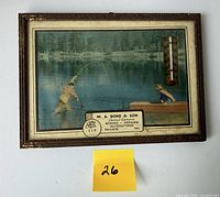 Front view showing entire framed thermometer with scene and advertising text