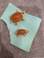 Both turtle brooches top view on paper