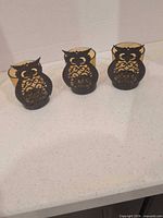 Full view of three matching owl tealight holders on countertop