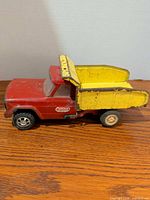 Full side view of red Tonka truck with yellow dump bed