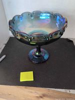 Full view of iridescent glass compote showing scalloped rim and pedestal