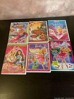 Front view of all six Barbie DVD cases